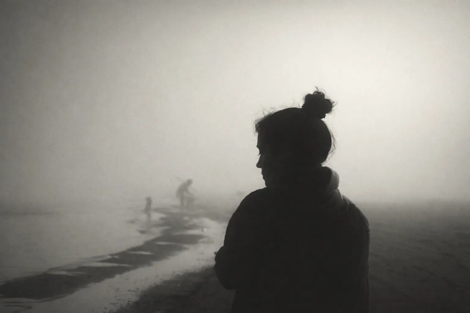 Rear view of a woman in athletic wear standing with hands on hips against a cloudy sky.