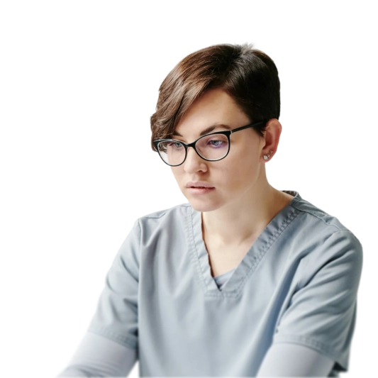 Young healthcare professional with short hair and glasses wearing light blue scrubs looking down thoughtfully.