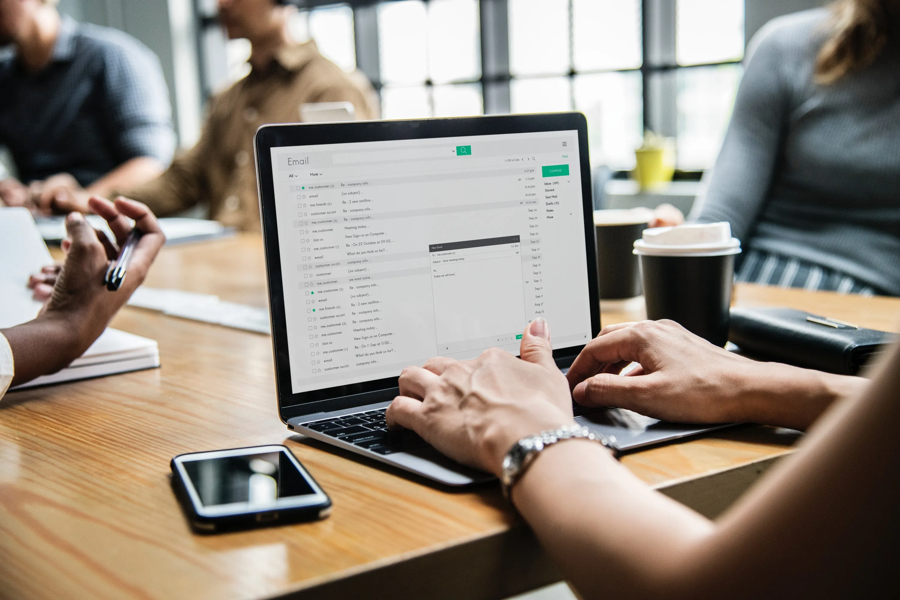 woman's hand on laptop with a view of emails.