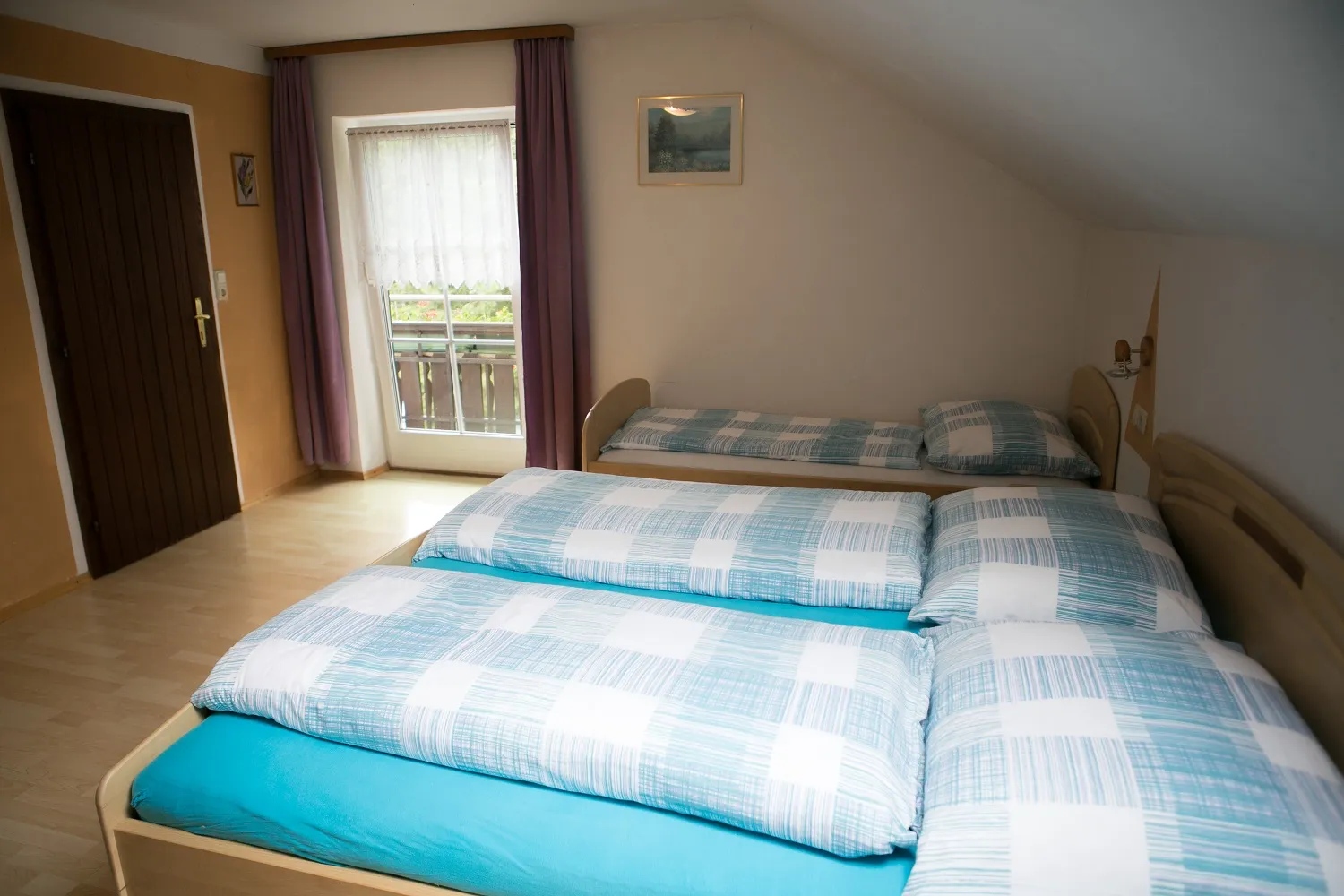 Schlafzimmer mit Doppelbett und Balkontür in der Ferienwohnung Löwenzahn