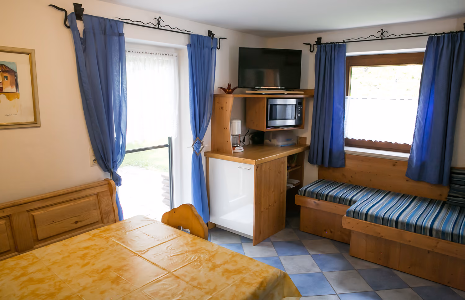 Wohnbereich mit Sitzbank und Terrassentür in der Ferienwohnung Teufelsgraben