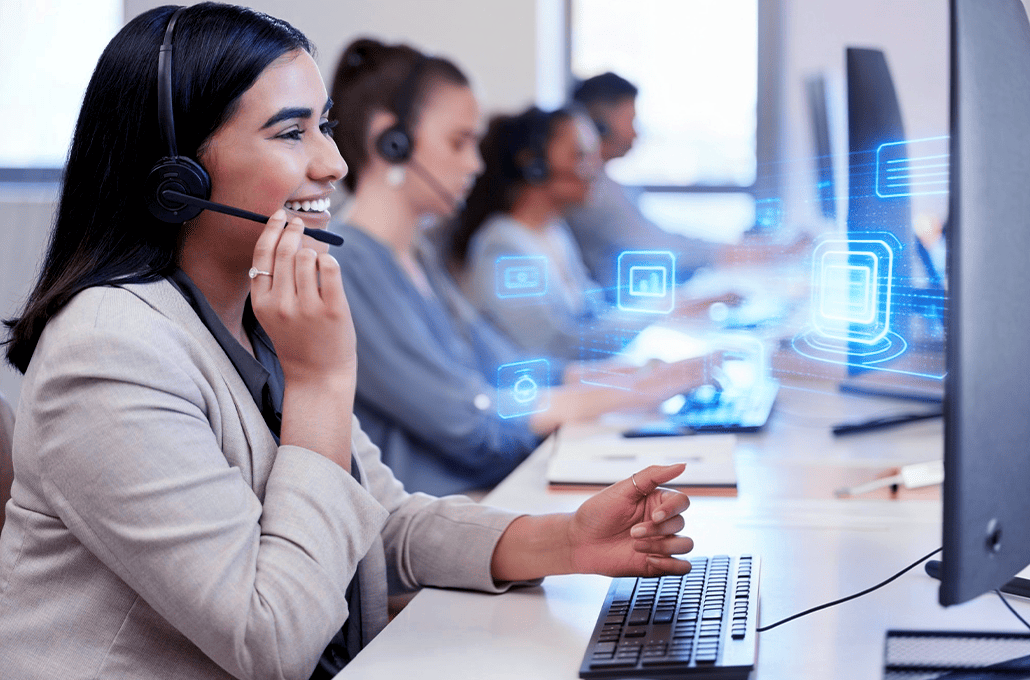 A customer service representative wears a headset while working at her desk in a call center.
