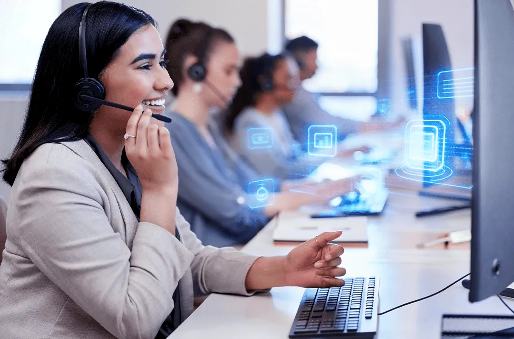 Une chargée de service client porte un casque d'écoute alors qu'elle travaille à son bureau dans un centre d'appels.