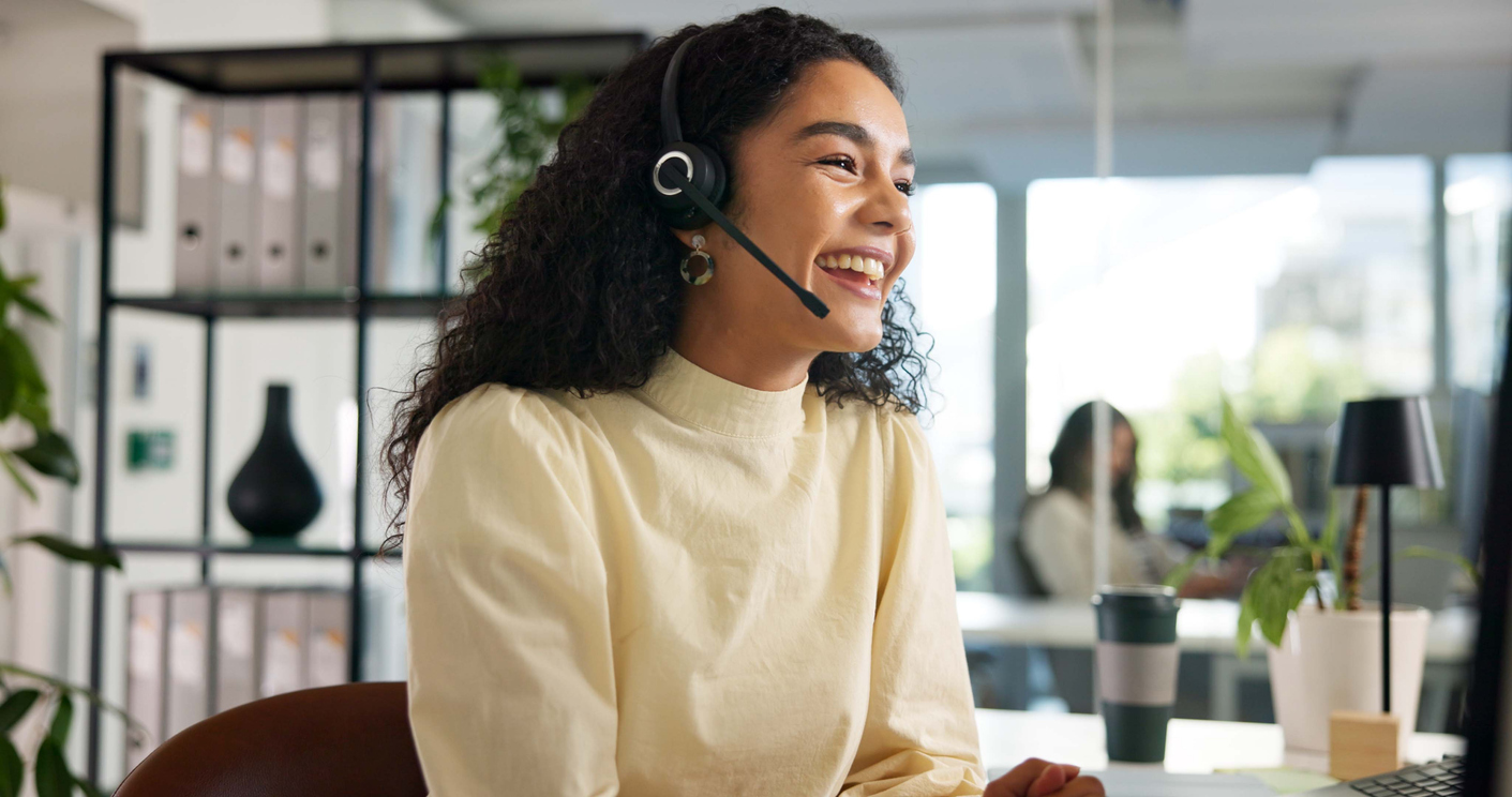 Laughing, happy woman and customer service in call center with agent, communication and online consulting. 