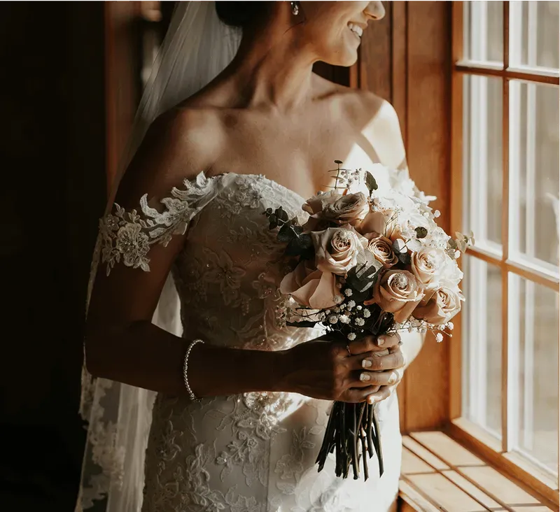 Mariée en robe de dentelle avec bouquet de roses au Relais d'Amboise, château pour mariage aux Châteaux de la Loire en Touraine.