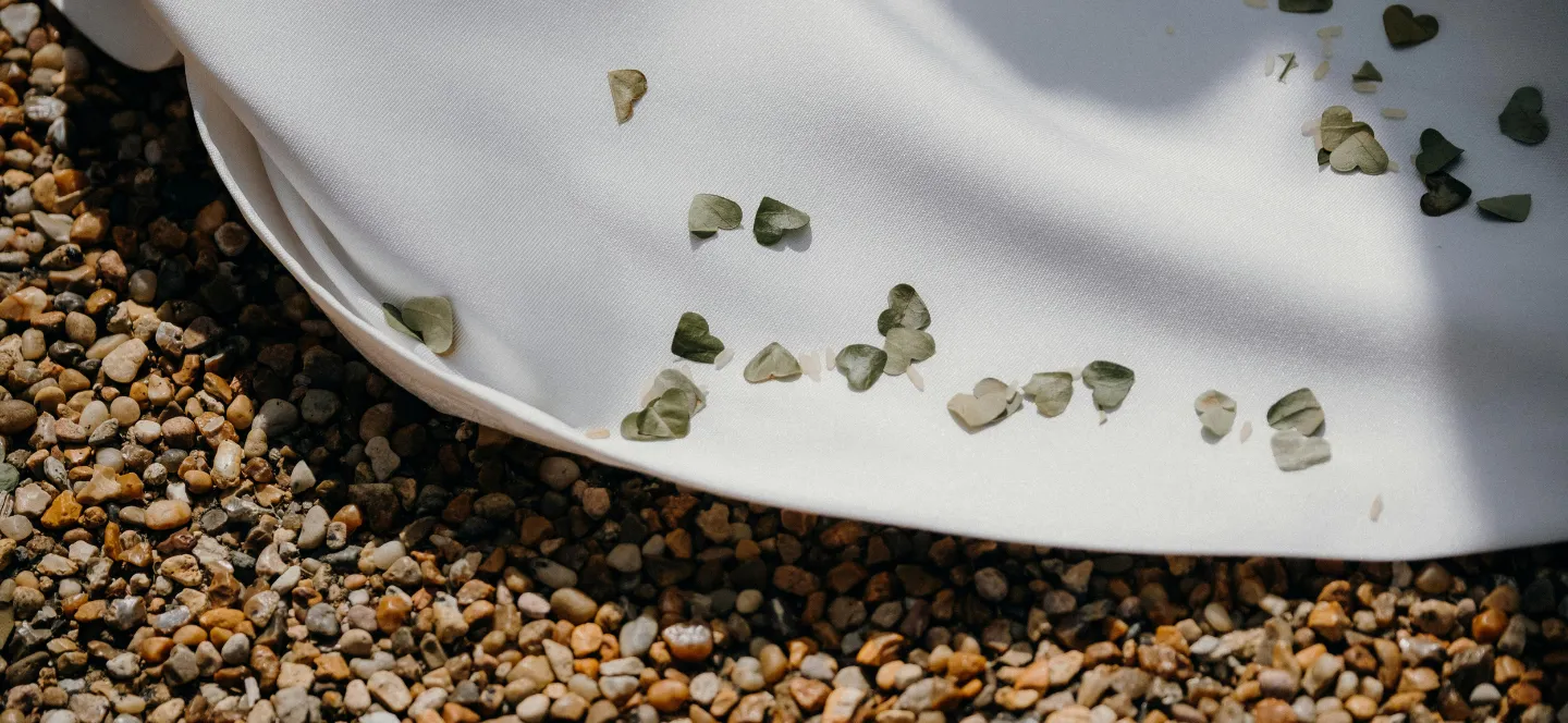 Flower petals on a white tablecloth during a wedding at the Relais d'Amboise, a wedding estate in the Loire Valley in Indre-et-Loire.
