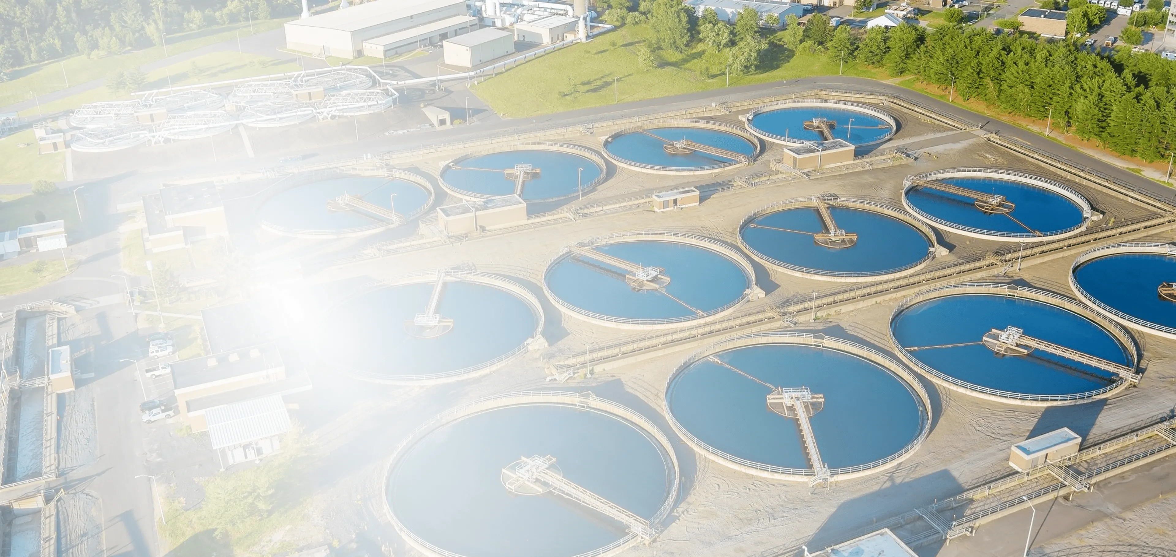 Multiple large blue industrial water pumps connected in a row with black motors in a clean indoor mechanical room.