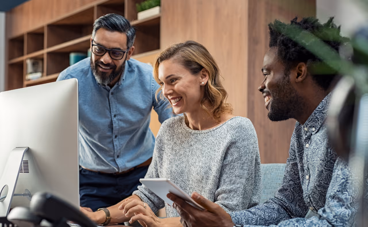 A collaborative group of business partners working together on a digital solution in a modern office environment.