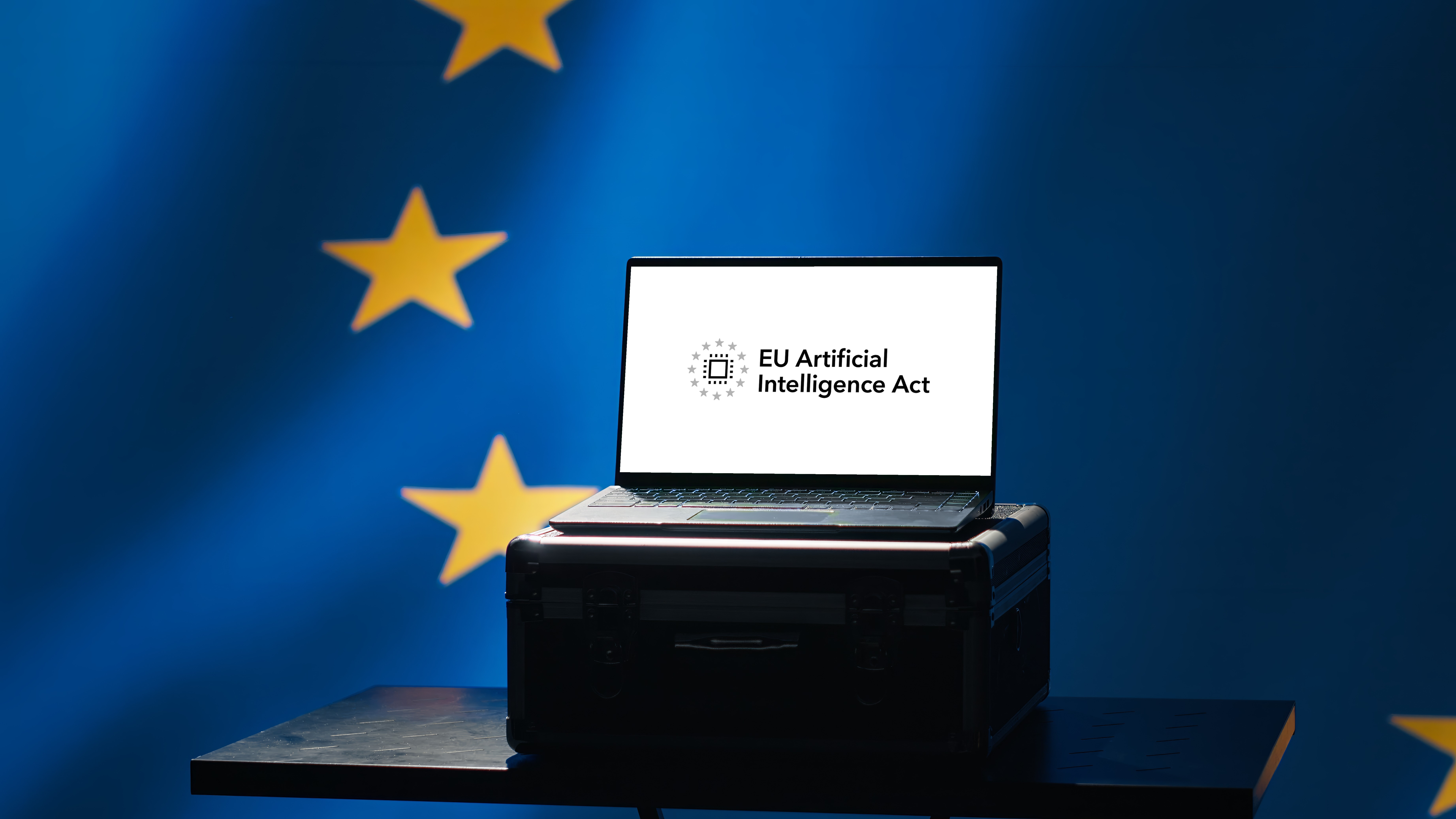 A laptop displaying the EU Artificial Intelligence Act against the European Union flag
