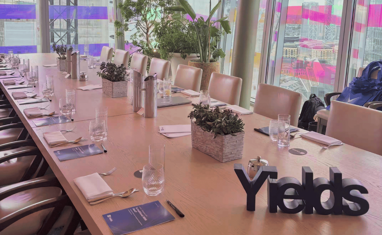 The roundtable room overlooking the City of London skyline, with the Yields name on the table
