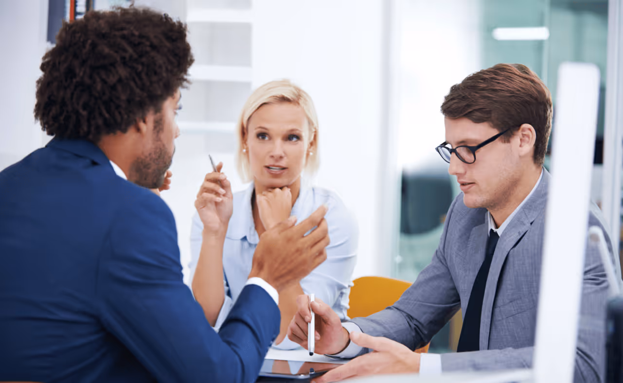 3 people in a meeting room discussing