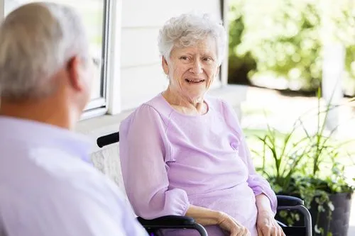 Husband sitting outside on the front patio with his wife laughing and talking together
