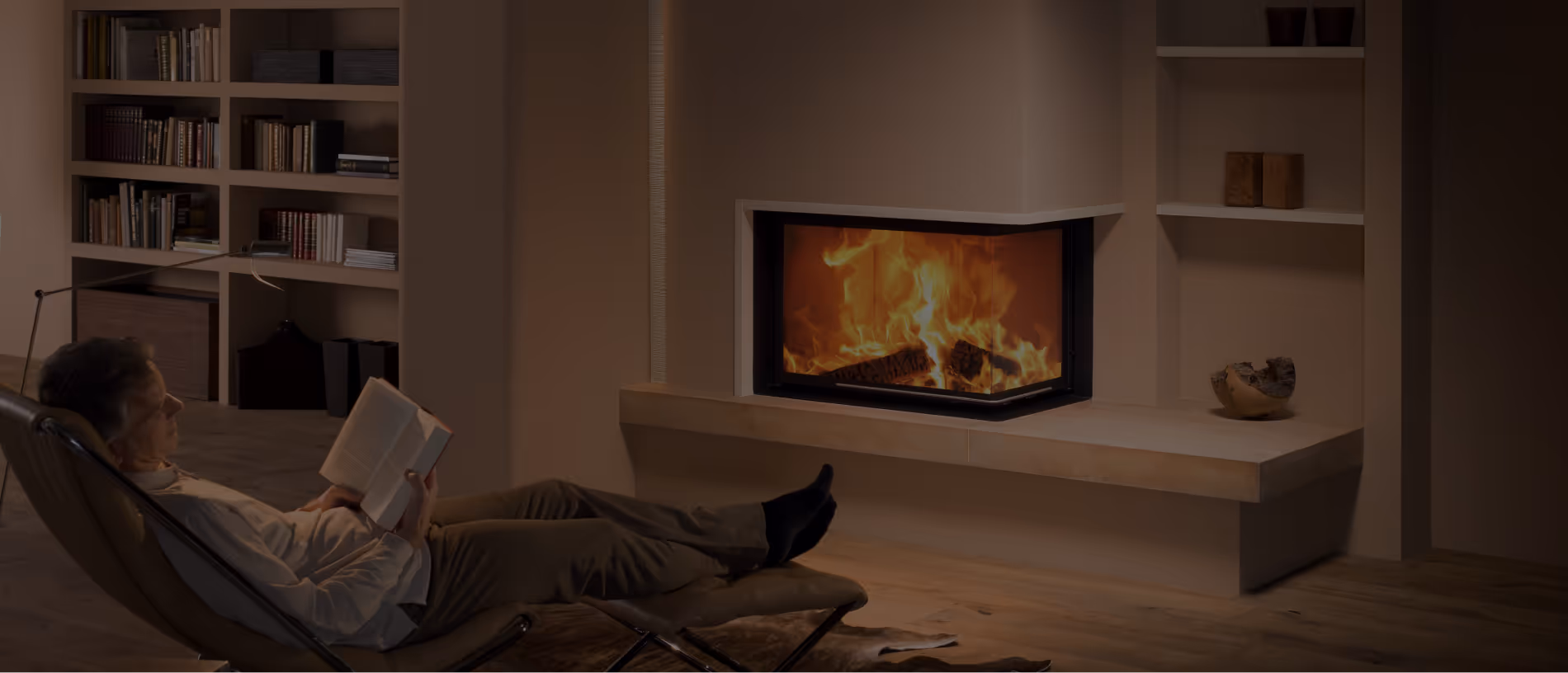 Mann liest vor Kaminofen vom Hafner