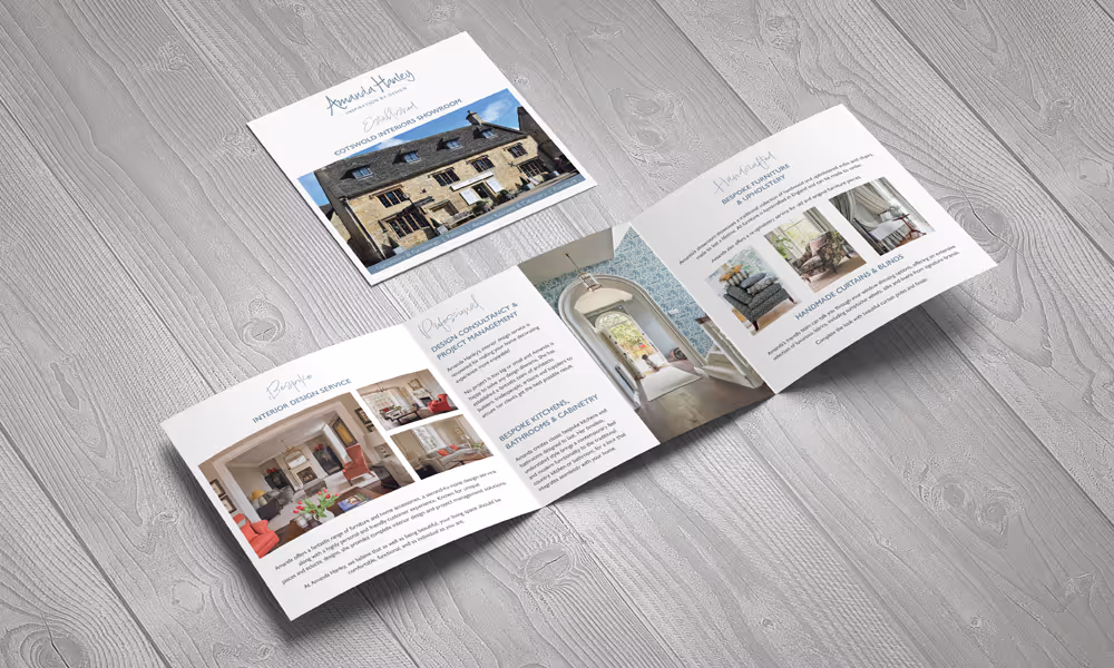 Open and closed brochures showcasing interior design services and a Cotswold Interiors showroom with images of home interiors and furniture.