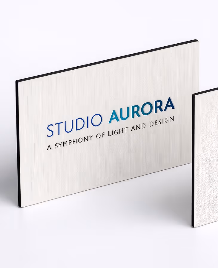White textured business card with the text 'STUDIO AURORA A SYMPHONY OF LIGHT AND DESIGN' in blue and black fonts.