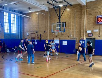 Students playing basketball in school gymnasium