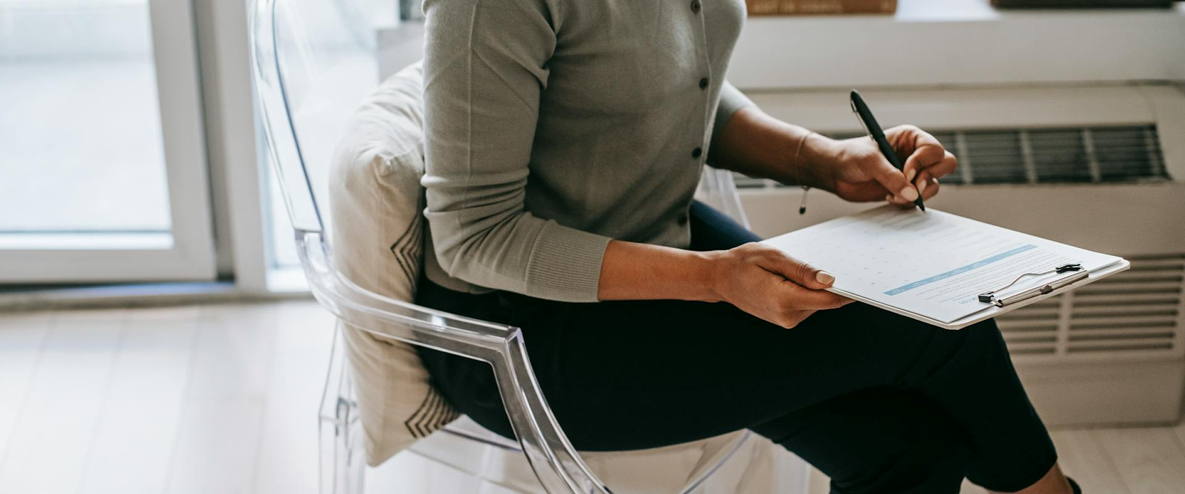 Two people sitting close with one person gently holding the other's hand in a comforting gesture.