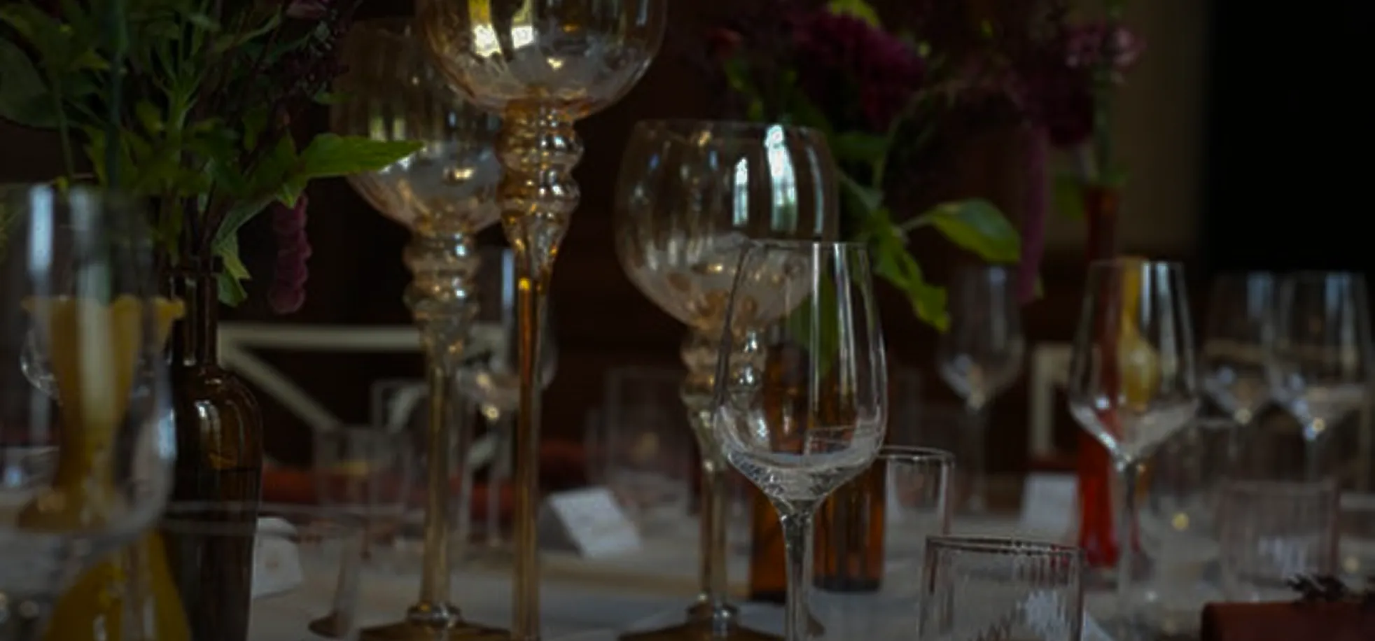 Table élégamment dressée avec verres et décoration florale pour réception traiteur haut de gamme