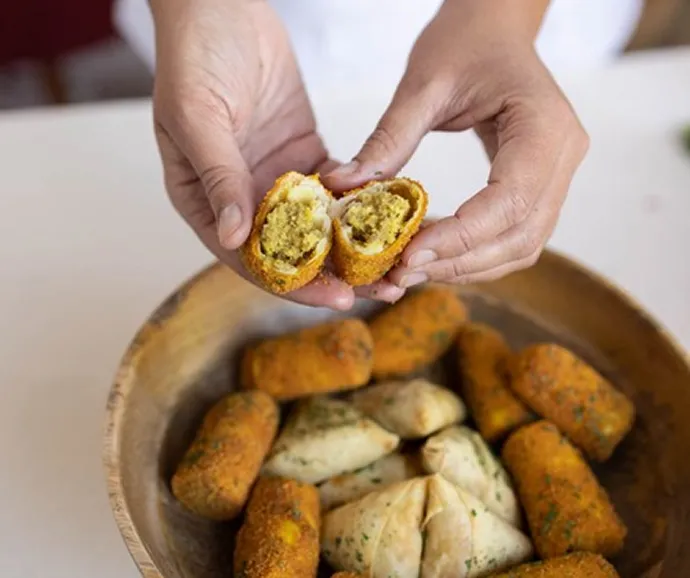 Service traiteur mettant en valeur des bouchées salées artisanales garnies et croustillantes présentées lors d’une expérience culinaire conviviale et authentique.