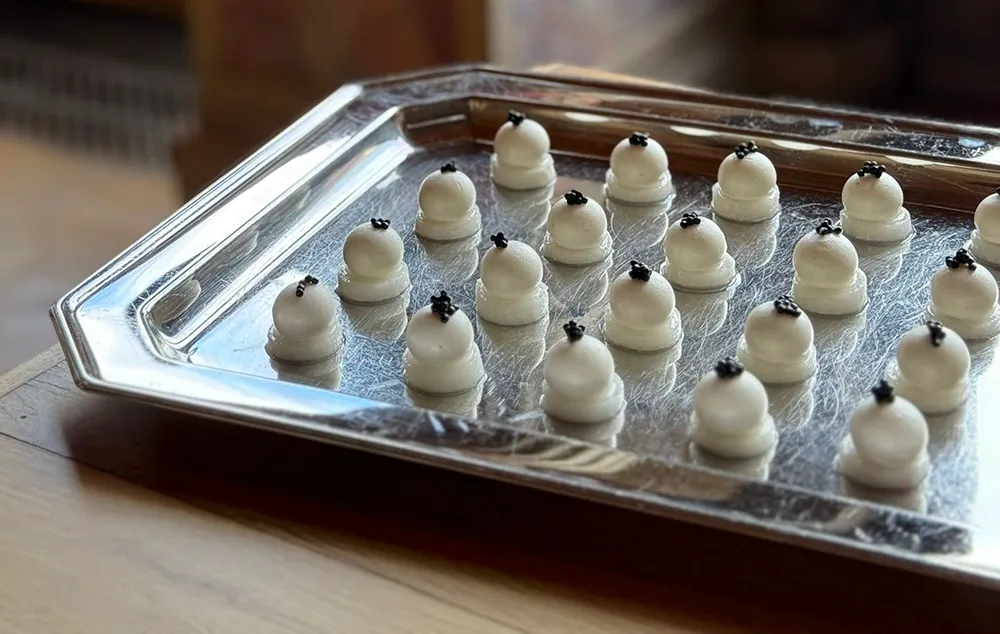 Bouchées gastronomiques blanches présentées sur plateau traiteur avec finition élégante et dressage raffiné