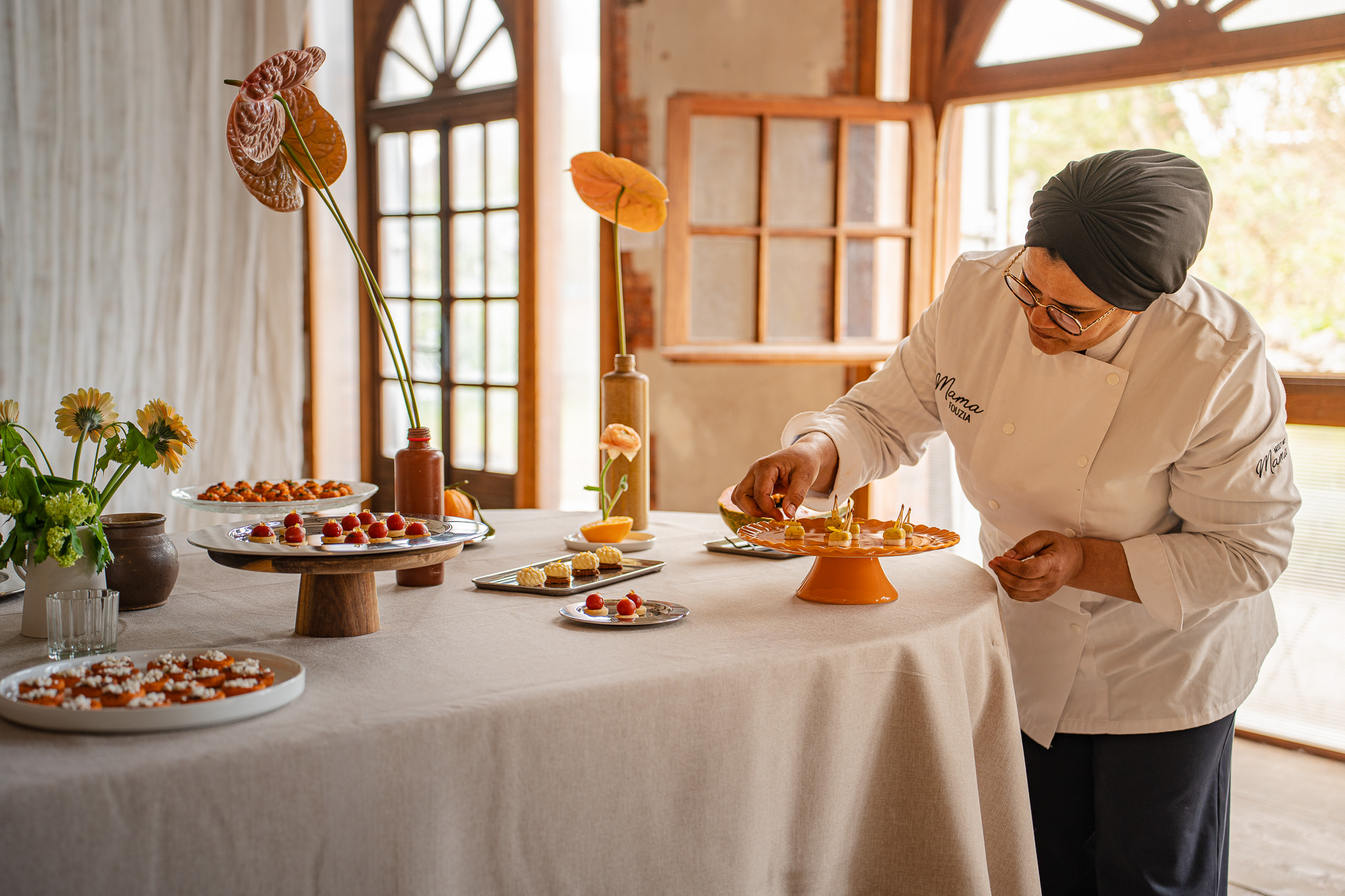 Cheffe en veste blanche dressant un dessert à l'assiette