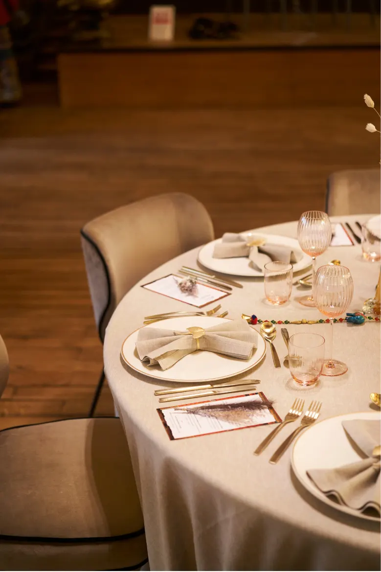 Main posant un menu sur une table dressée aux couverts dorés