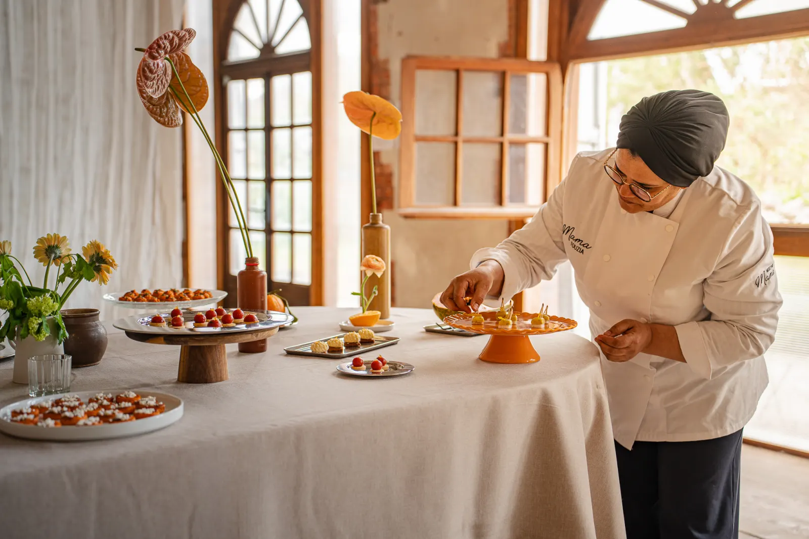 Cheffe en veste blanche dressant un dessert à l'assiette
