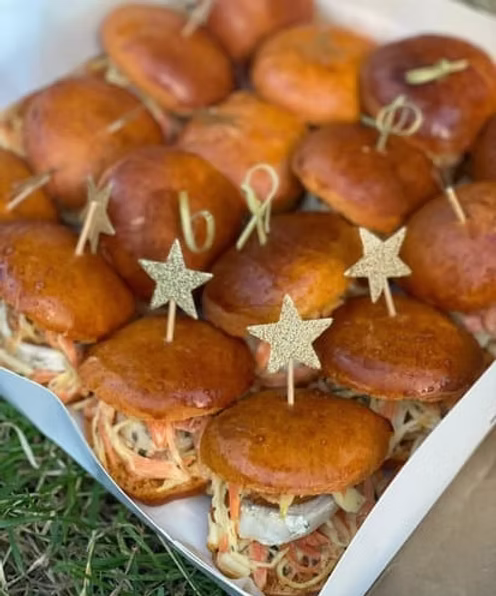 Une table extérieure élégante garnie de fruits frais, légumes de saison, pastèque, agrumes et bouchées apéritives, accompagnée de compositions florales colorées, illustrant une expérience traiteur printanière fraîche et conviviale.