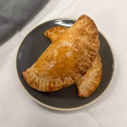 Empanadas dorées et croustillantes garnies présentées à l’assiette dans un concept de traiteur aux saveurs authentiques inspirées de la cuisine traditionnelle