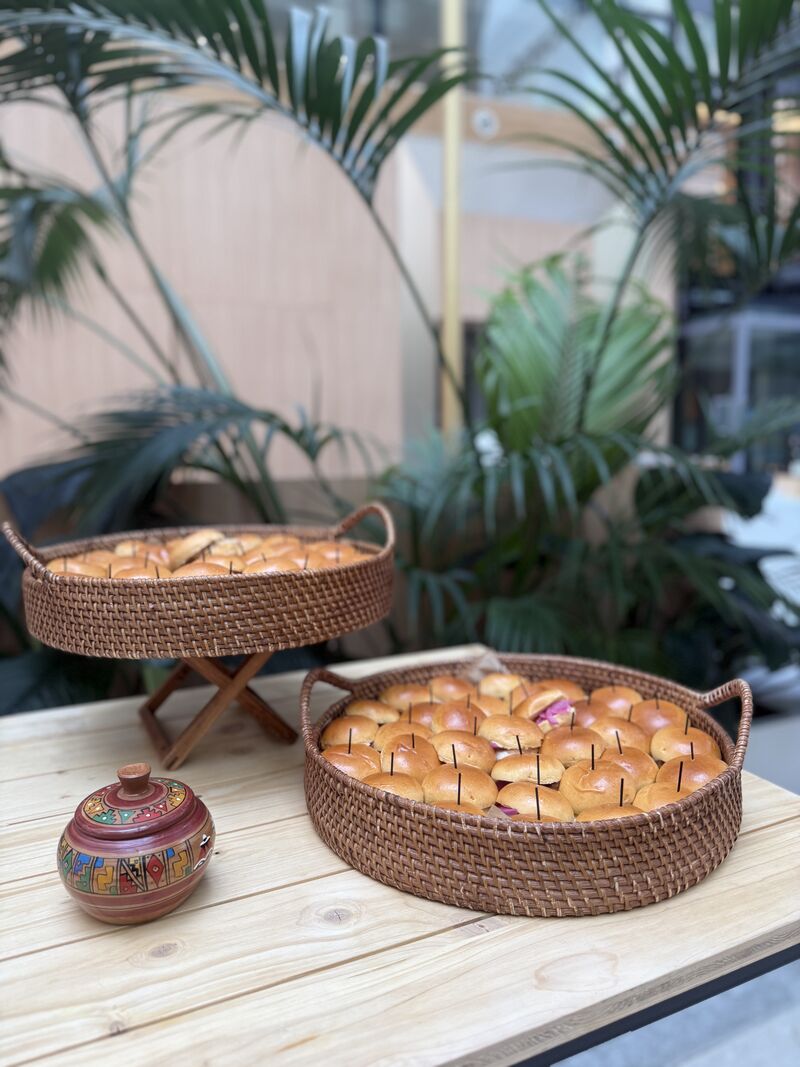 Une table extérieure élégante garnie de fruits frais, légumes de saison, pastèque, agrumes et bouchées apéritives, accompagnée de compositions florales colorées, illustrant une expérience traiteur printanière fraîche et conviviale.