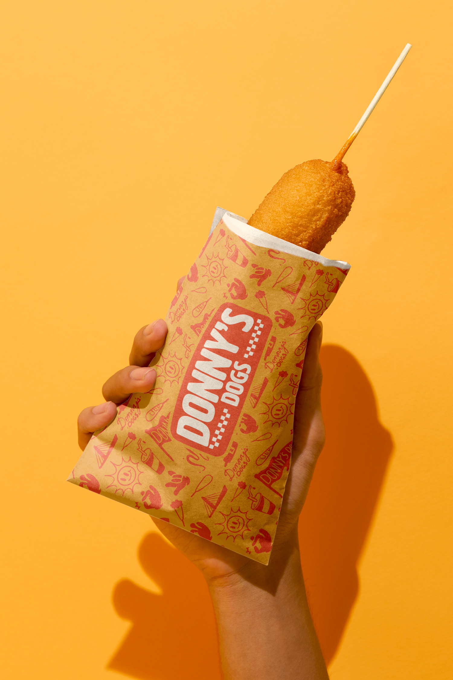 Corn dog wrapped in Donny's Dogs custom food packaging.