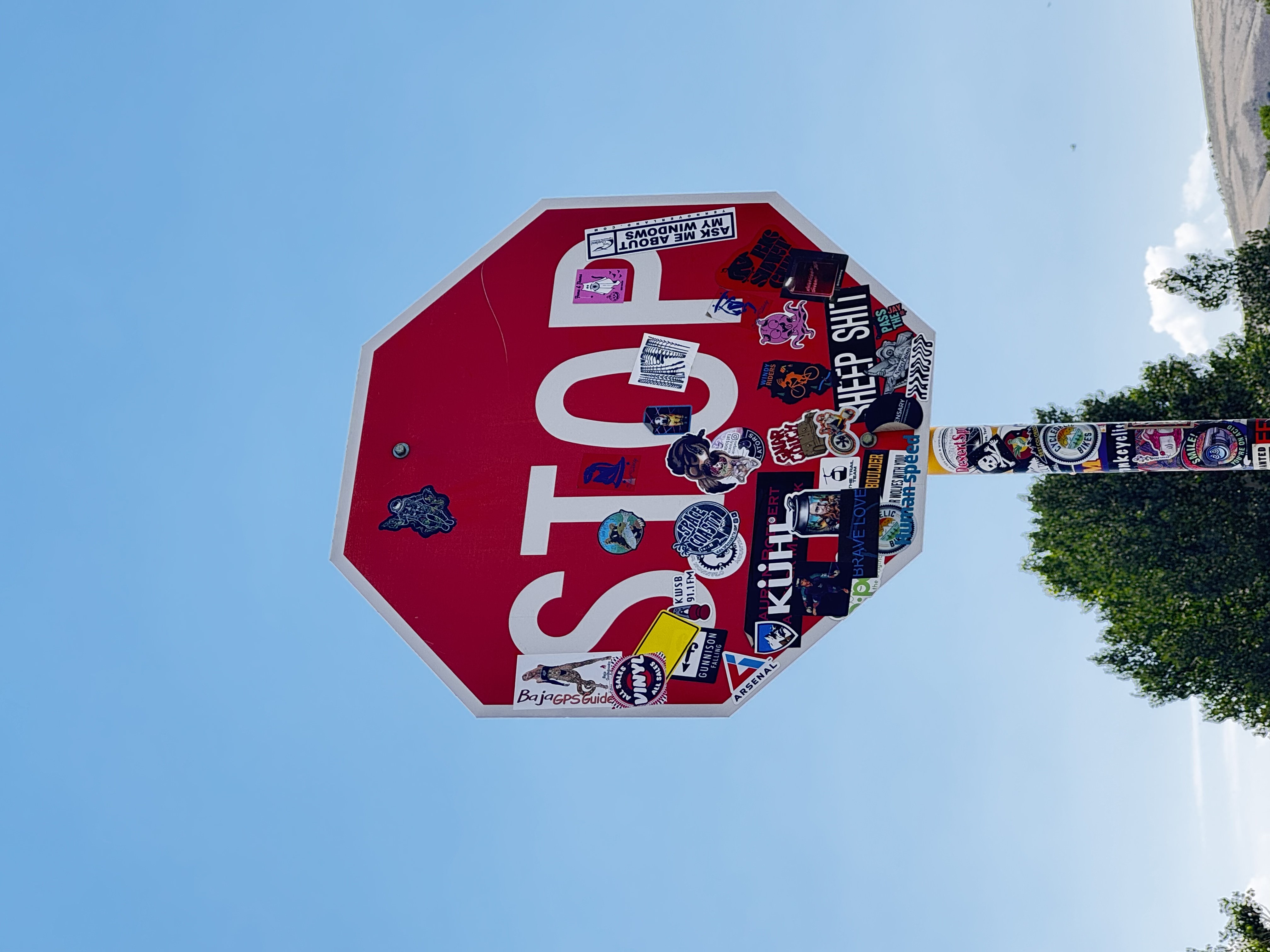 A STOP sign covered in layered stickers.