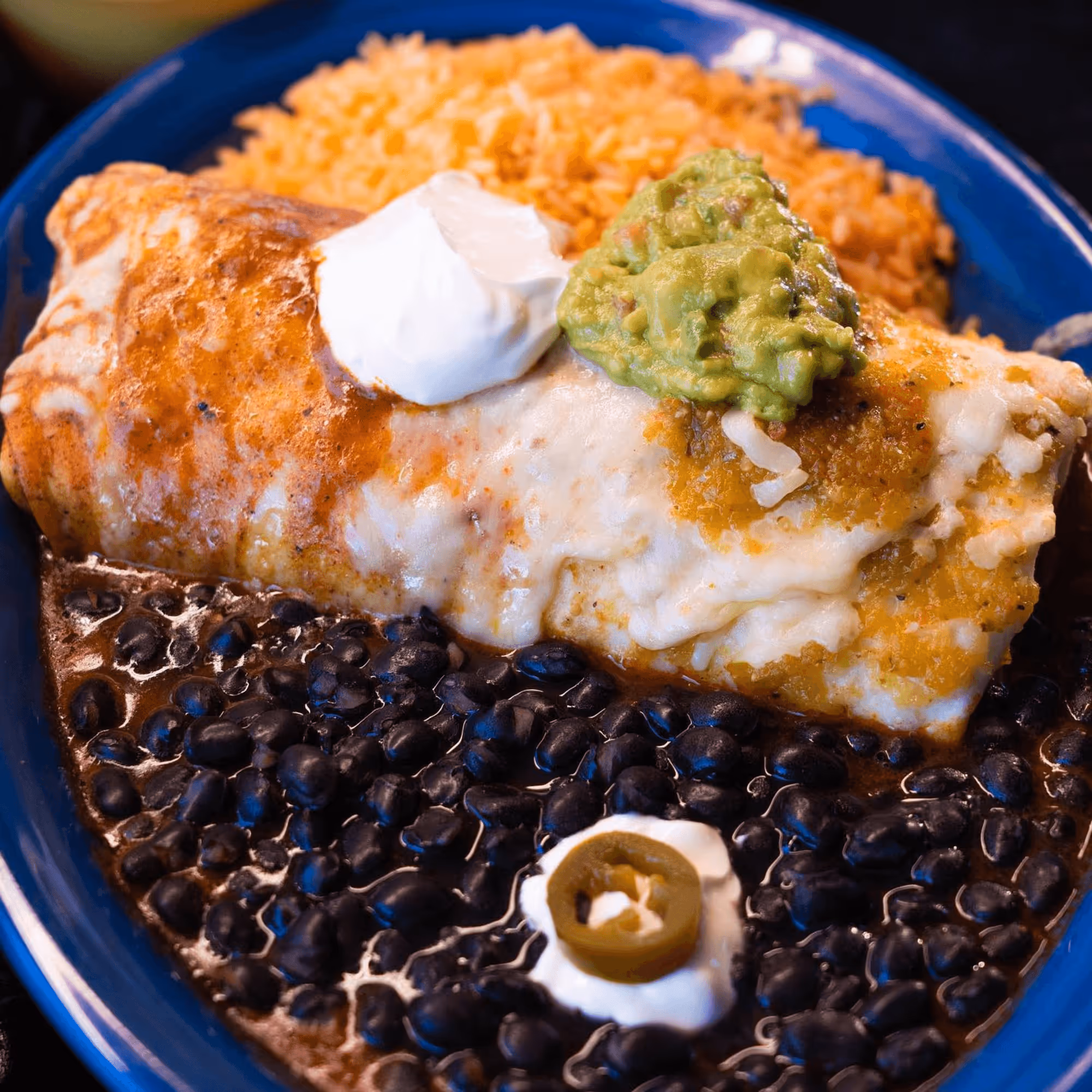 A plate of food with a green olive on top.