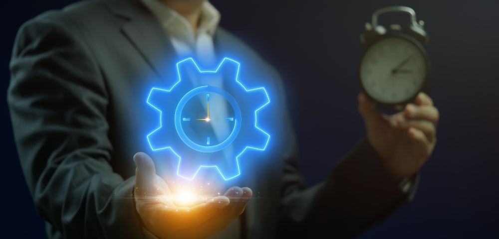Businessman in suit holding an alarm clock and a glowing blue gear-shaped clock icon representing time management.