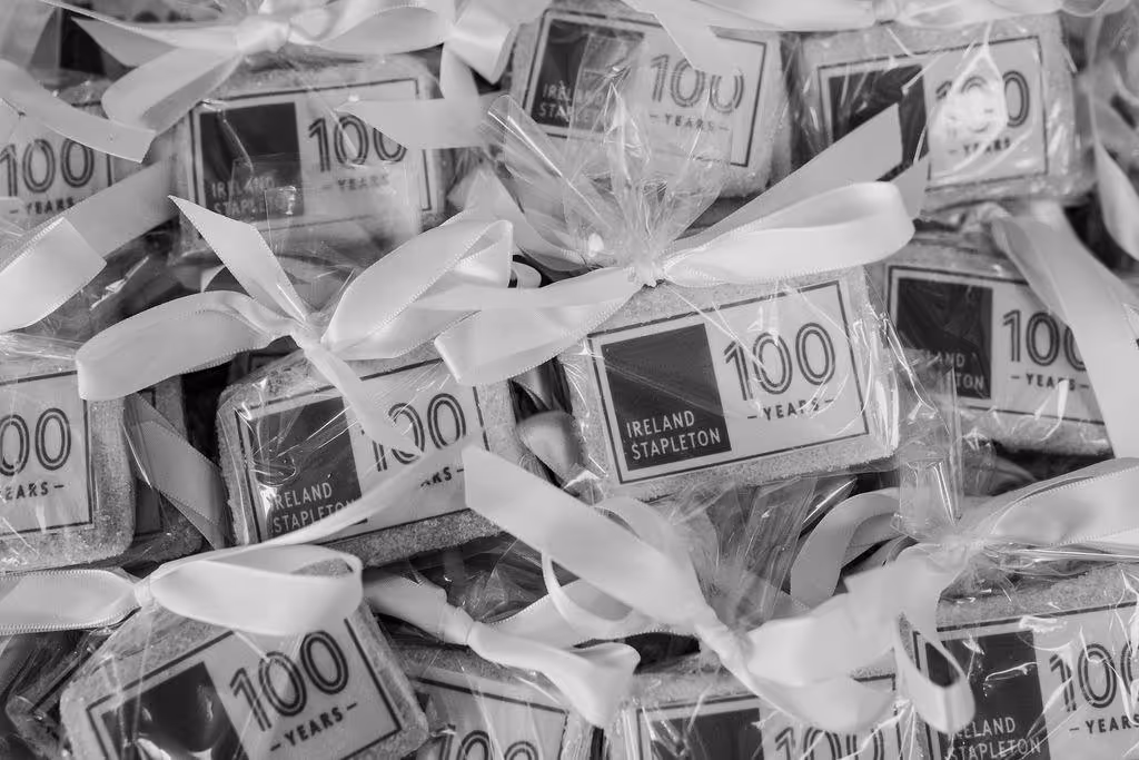 Wrapped cookies with white ribbons, each labeled 'IRELAND STAPLETON 100 YEARS'.