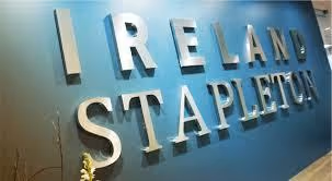Wall with large 3D letters spelling 'IRELAND STAPLETON' in a modern font on a blue background.