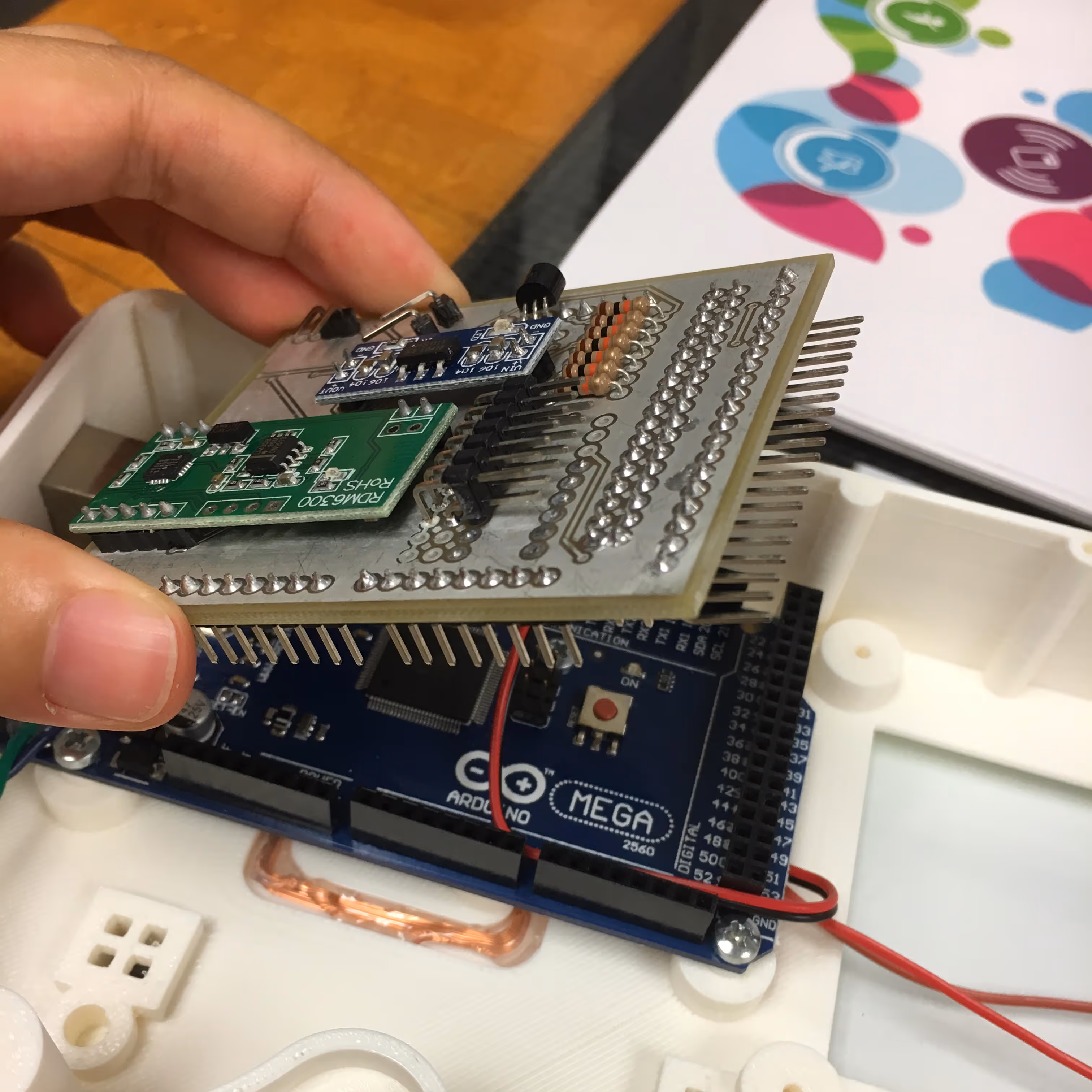A hand sets the circuit board for one of the ADL 1-2-3 devices in place