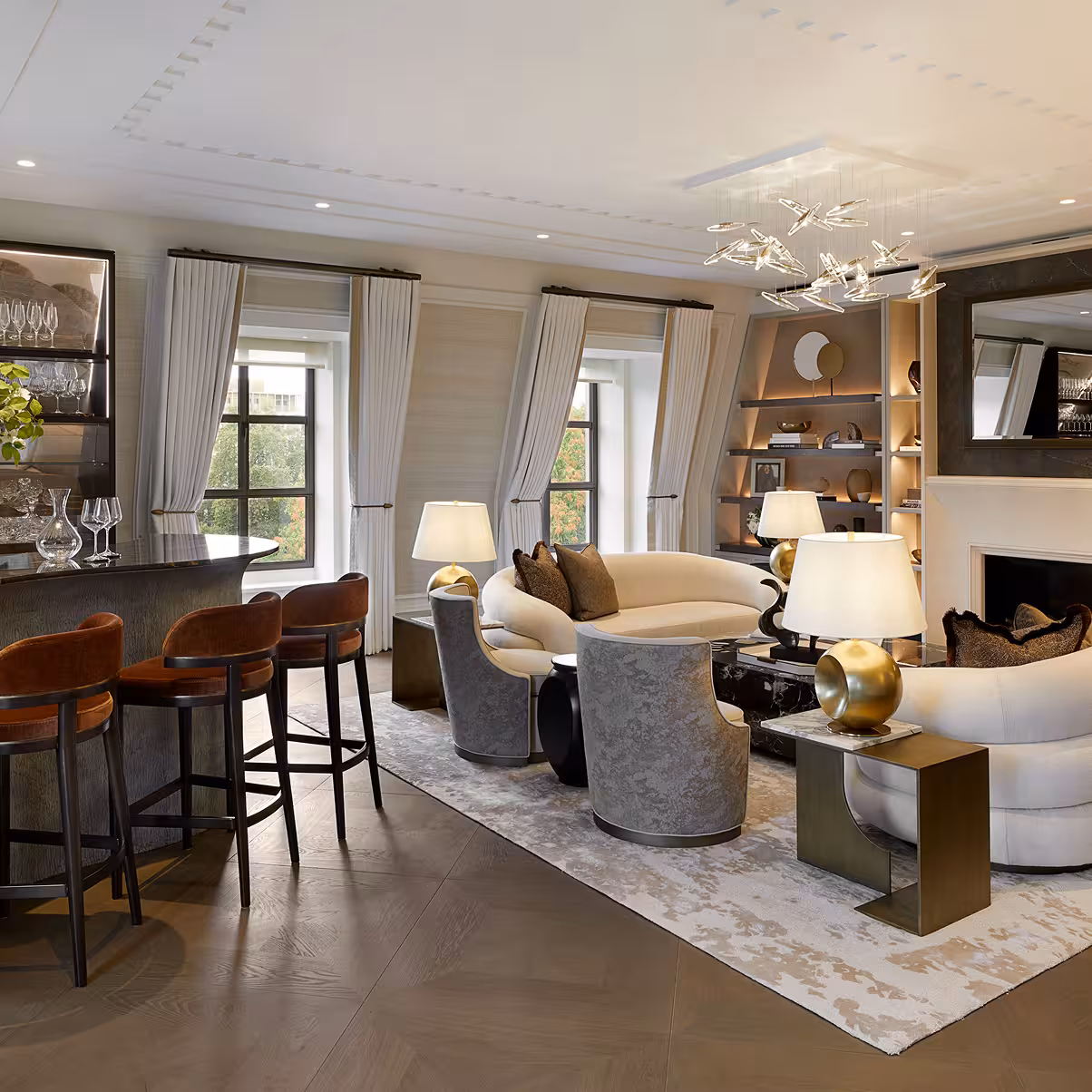 A luxury living room with a pair of white curved sofas, wooden floors and a curved hand build bar area