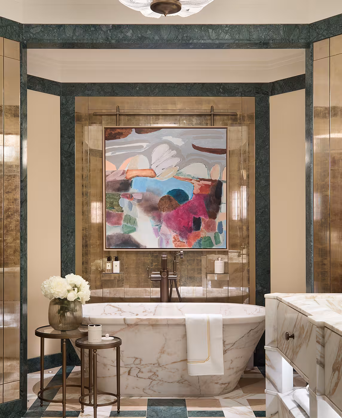 Marble bath sat in front of a large painted peice of artwork on the wall.