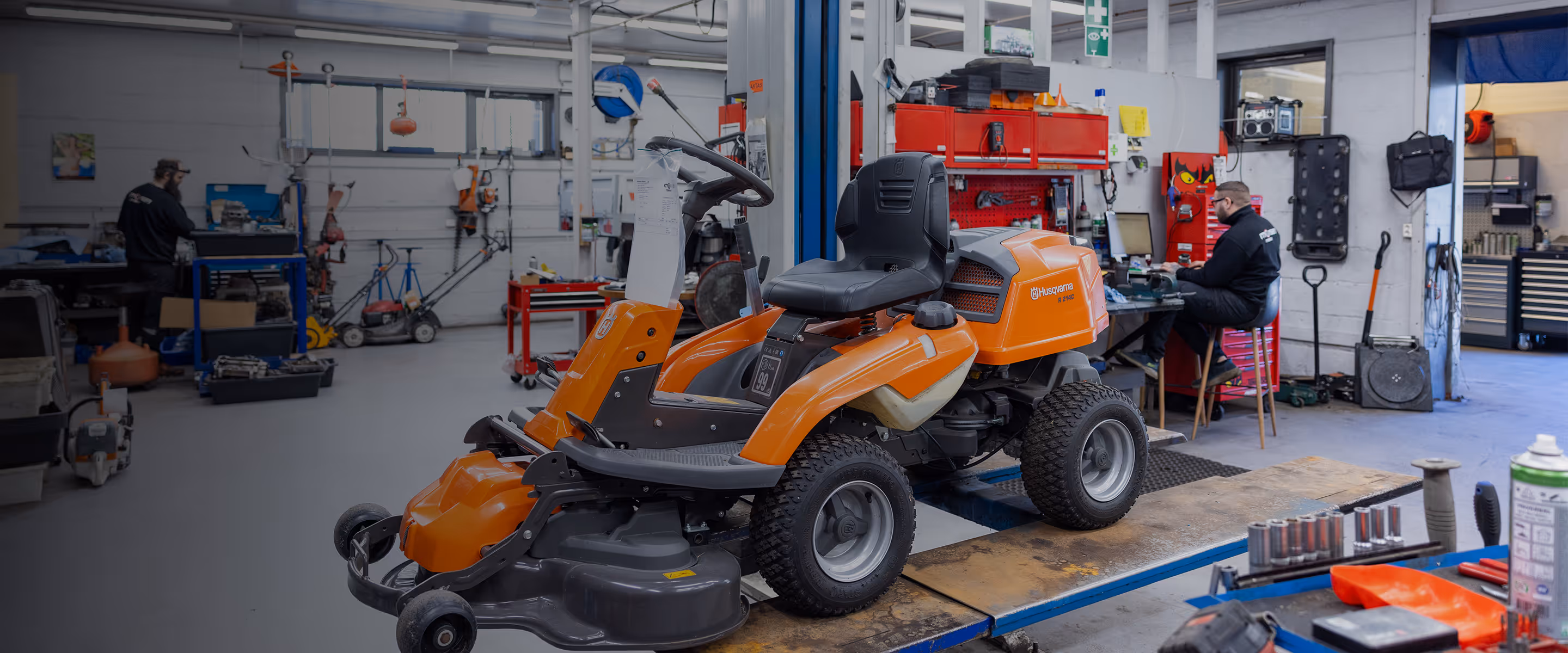 Verkstedet hos Monsen Maskin, med en sittegressklipper i forkant.
