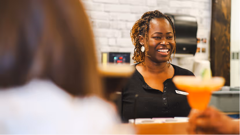 A server at Eggsmart Collingwood laughing and chatting with guests
