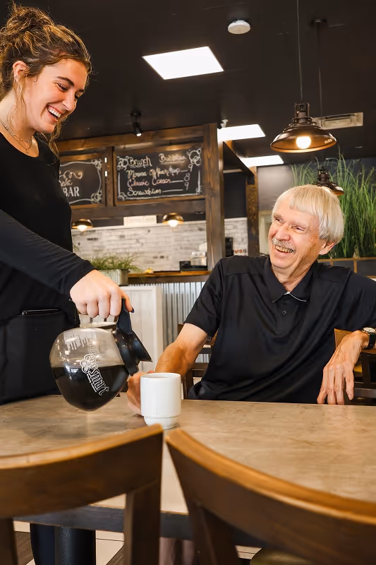 A server at Eggsmart Collingwood laughing and chatting with guests