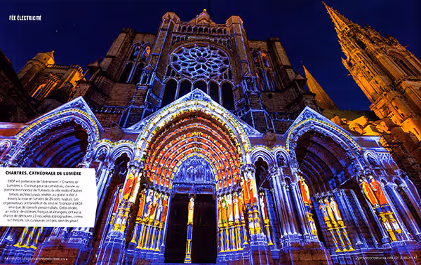 Façade illuminée en couleurs vives de la cathédrale de Chartres lors de l'événement Chartres en Lumières la nuit.