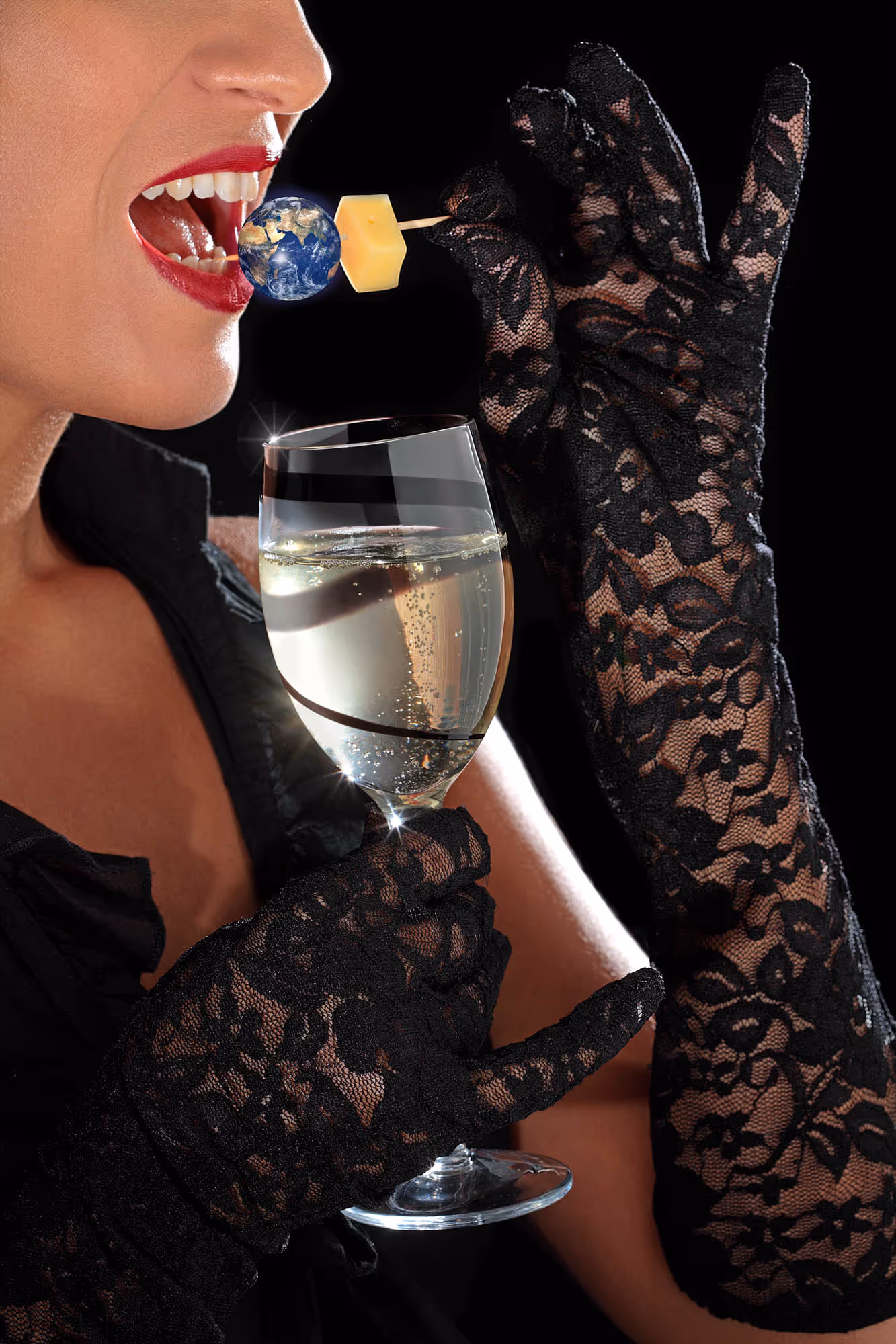 Femme portant des gants en dentelle noire tenant un verre de vin blanc et portant une brochette avec une petite Terre et un cube de fromage à sa bouche.