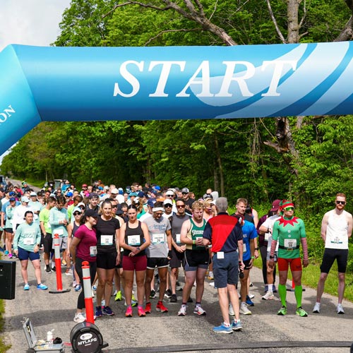 A large group runners preparing to begin running the Pelee Island Half Marathon.