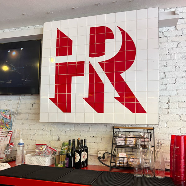 Highroller Lobster Co. Logo on the wall behind the bar