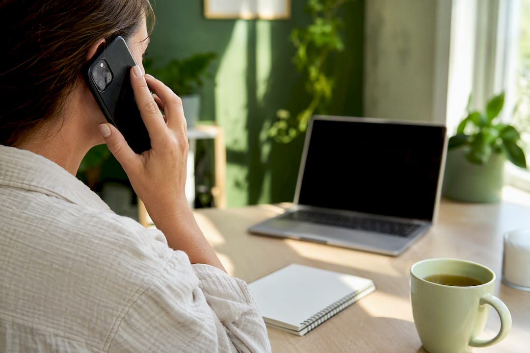 Hands holding smartphone for support call at table