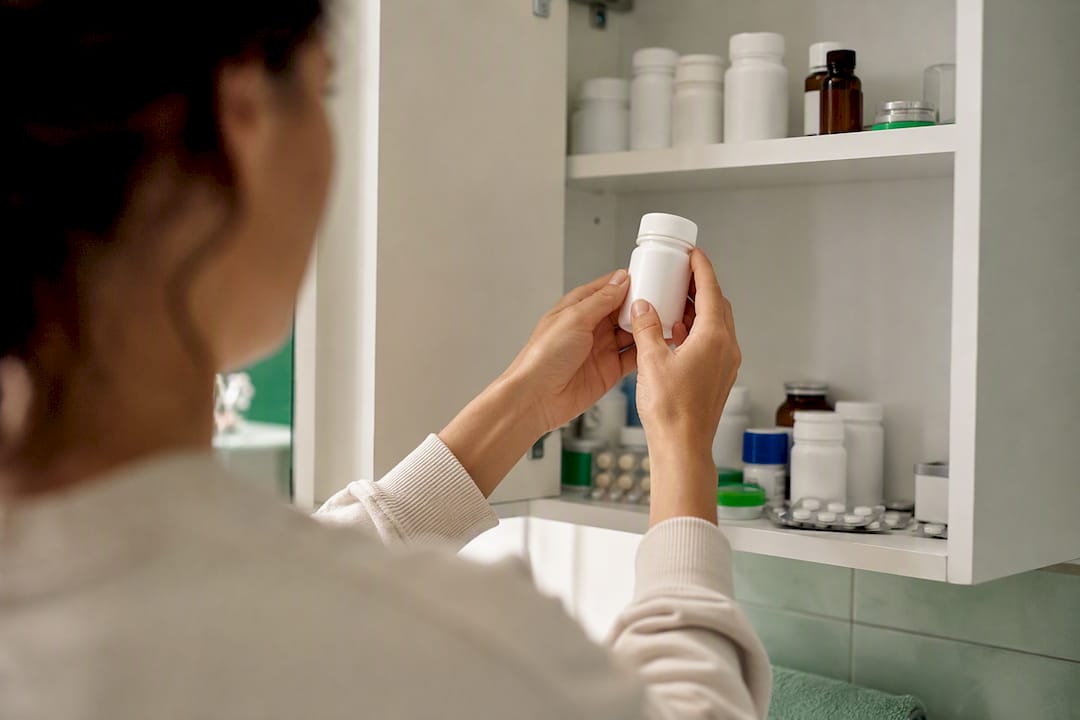 Hands reaching for medication in cabinet