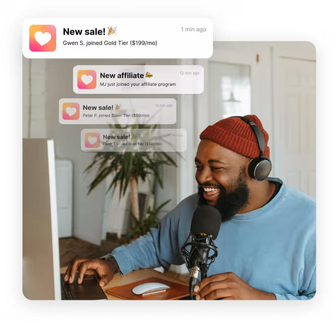 Smiling man wearing headphones and a red beanie speaking into a microphone at a desk with a computer, with overlay notifications about sales and affiliate sign-ups.