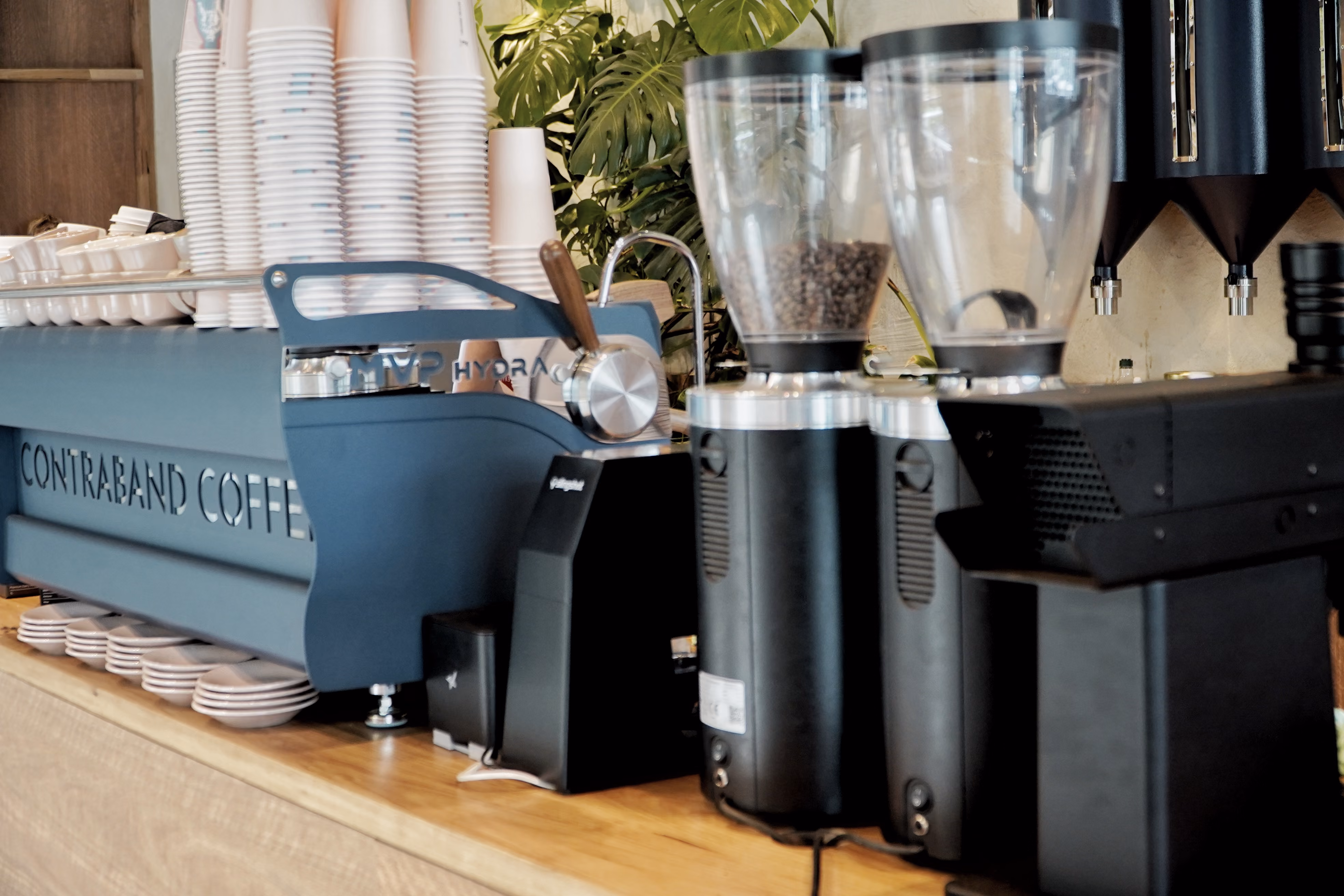 Contraband's blue espresso machine and grinders on the cafe counter